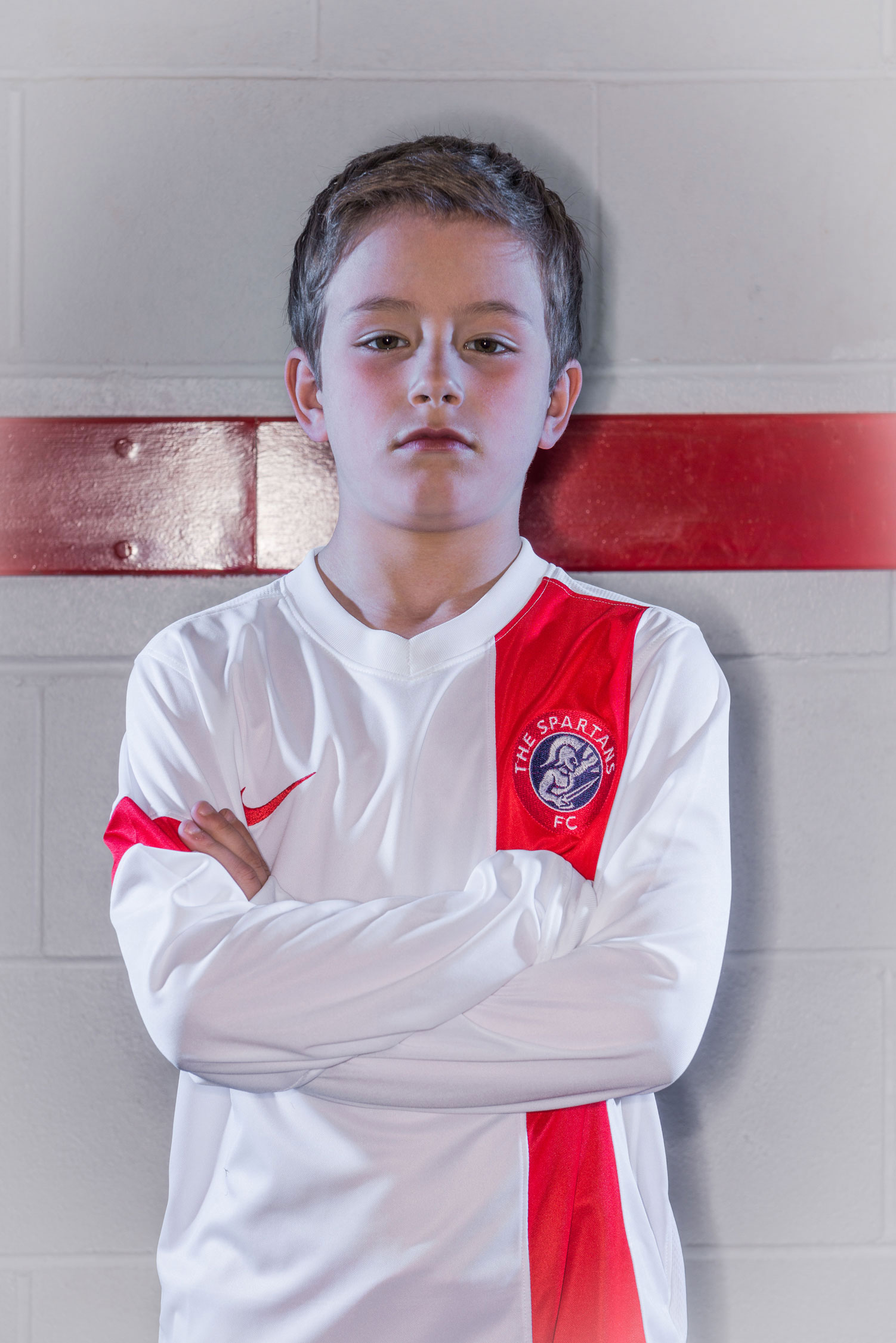 Portrait of young boy in football kit in changing room, Edinburgh