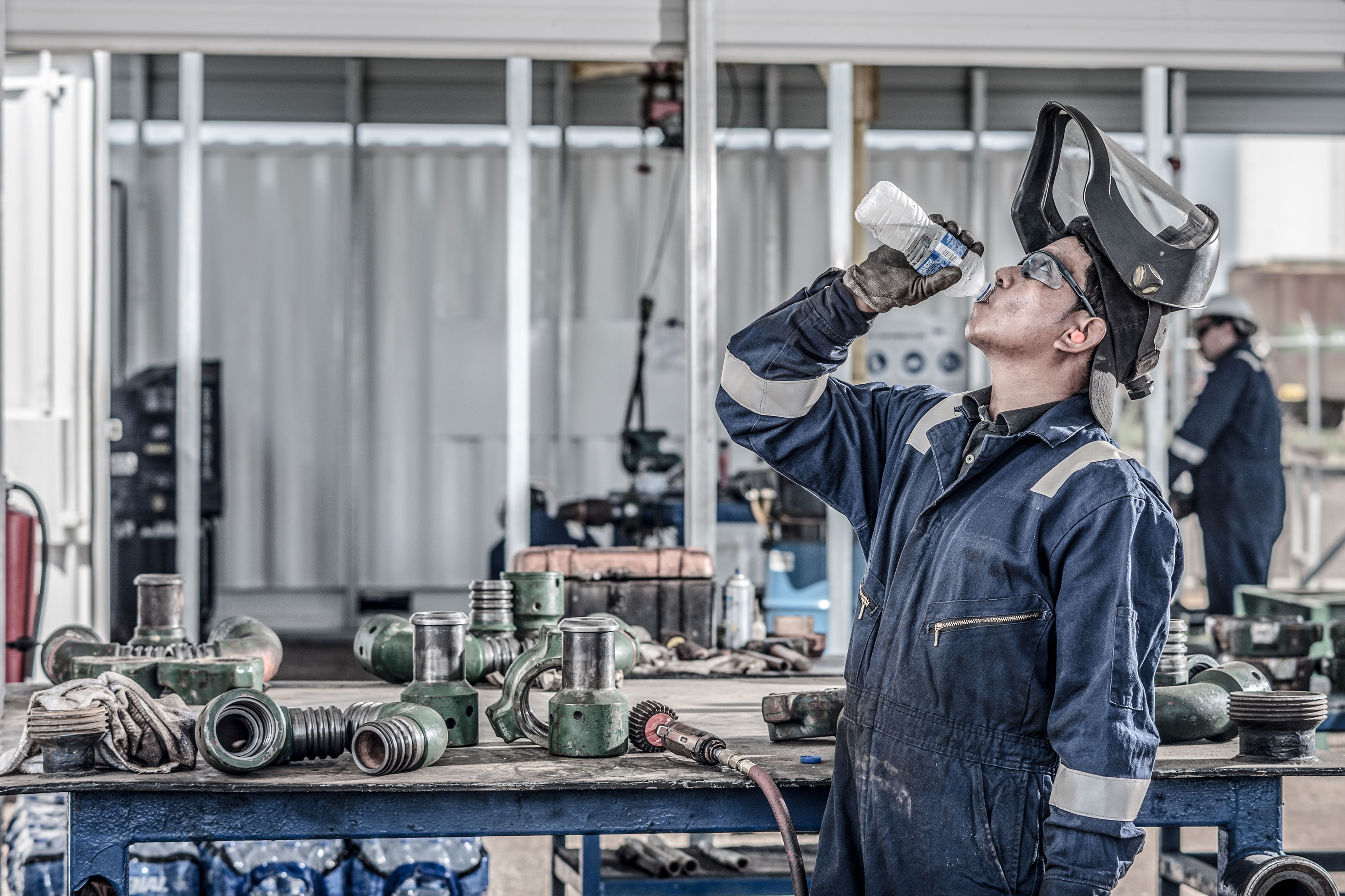 Man drinking water in industrial setting 